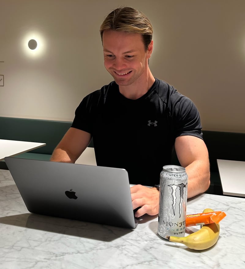 Coach jobber med den bærbare datamaskinen sin.